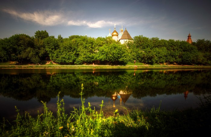 Monastery domes reflected in a river with trees