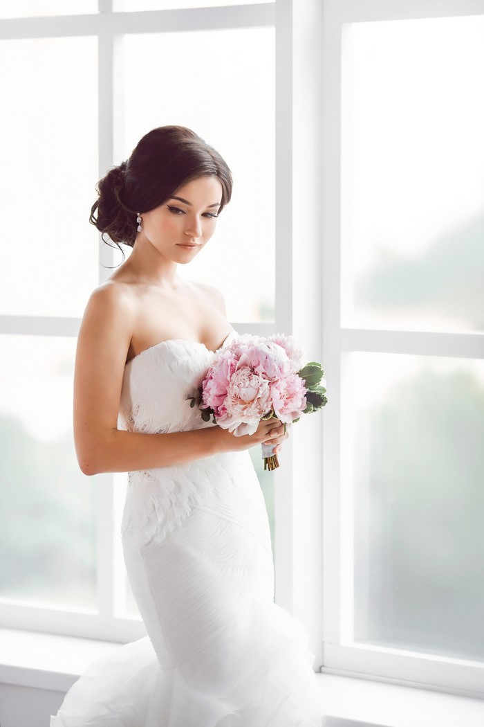 Bride in a white dress holding a pink bouquet
