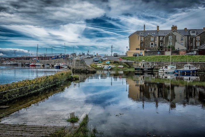 Boats docked in a harbor with houses in Aberystwyth, Wales