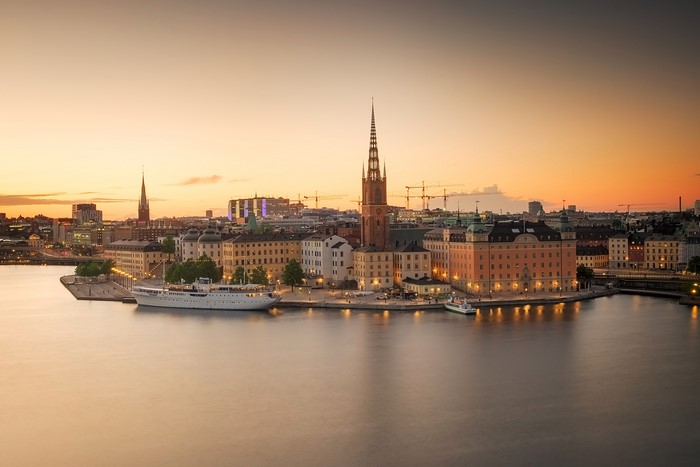 Stockholm cityscape with church spire and harbor at sunset