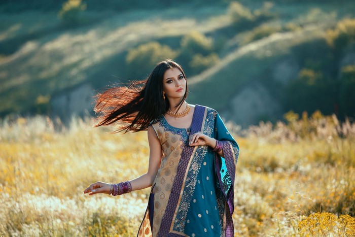 Brunette woman in traditional Indian attire in a field