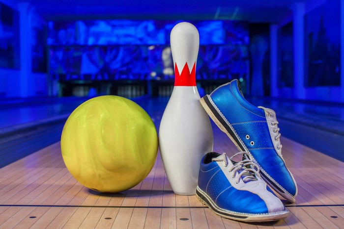Bowling ball, pin, and shoes on lane