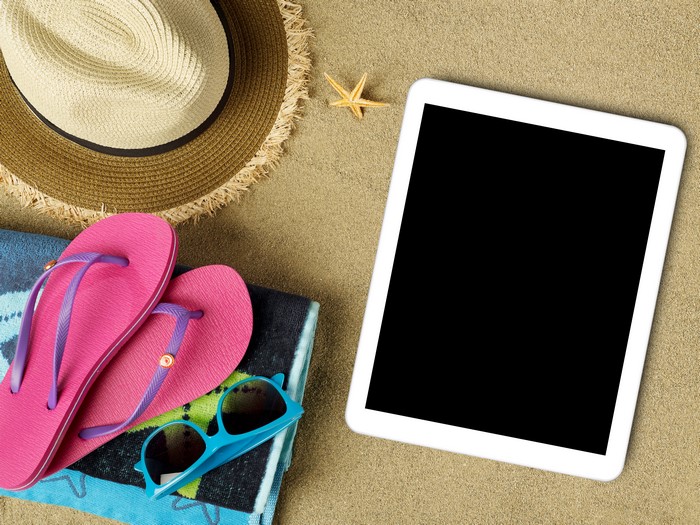 Beach accessories on sand with tablet