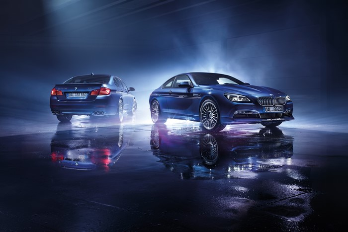 Two blue BMW Alpina cars with reflections