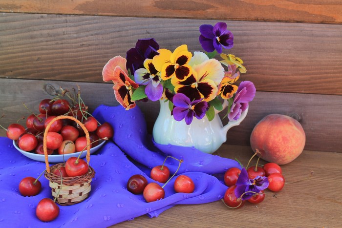 Still-life with cherries, peaches, pansies, and a wicker basket