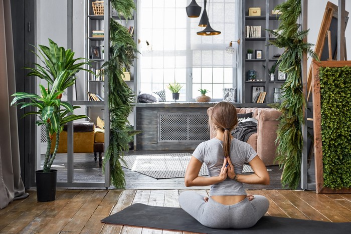 Woman doing yoga in a room with plants
