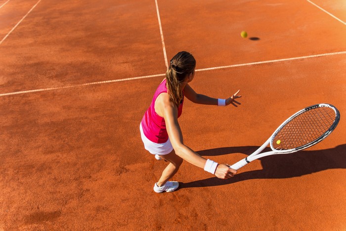 Woman playing tennis on a clay court
