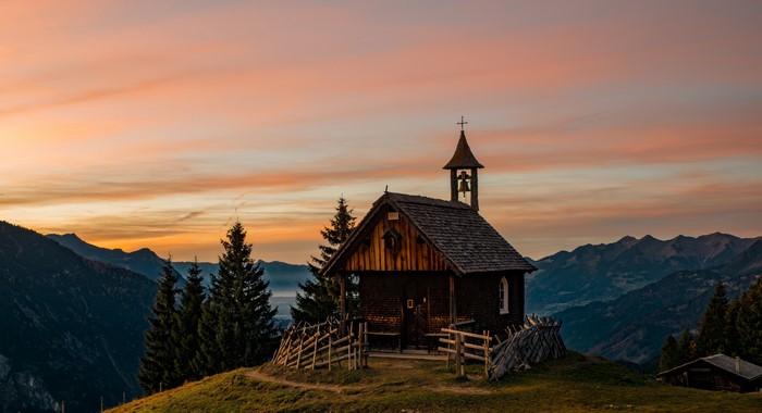 Wooden church in Austrian Alps at sunset