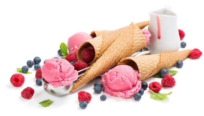 Pink ice cream scoops with raspberries and blueberries in cones