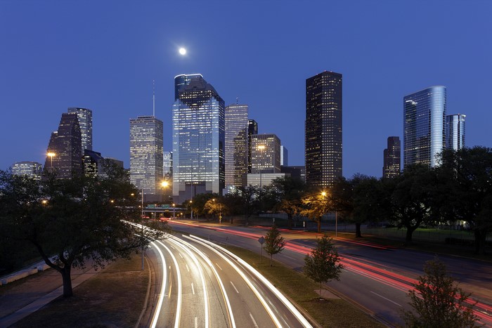 Houston skyline with moon and light trails at night