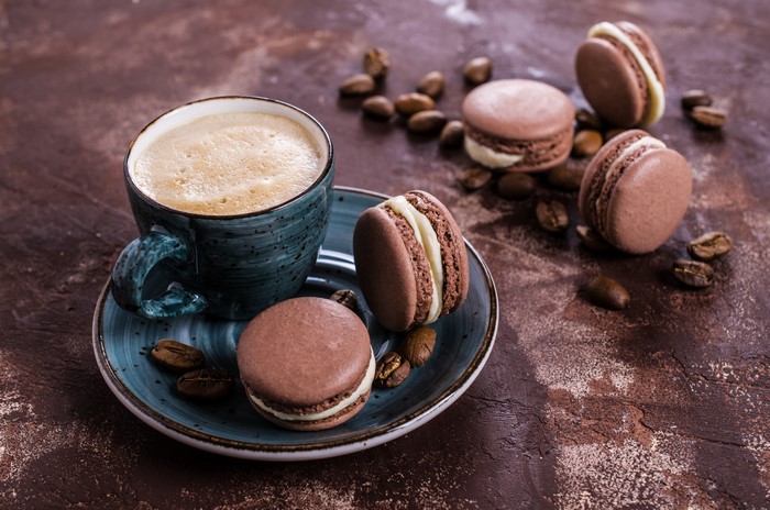 Coffee cup with macarons and coffee beans