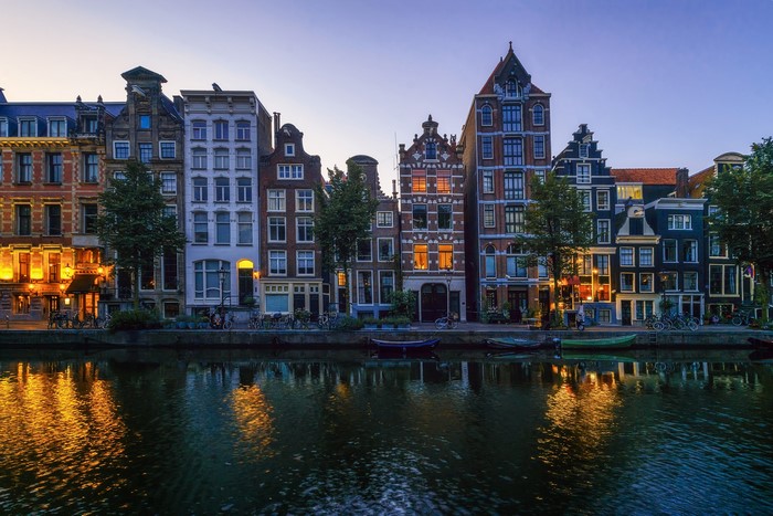 Amsterdam canal houses at dusk with reflections