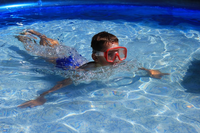 Boy swimming with goggles in a pool