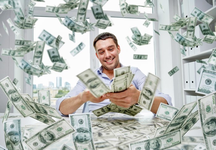 Man happily throwing money in the air
