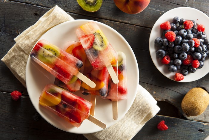 Fruit popsicles with berries and kiwi on a plate
