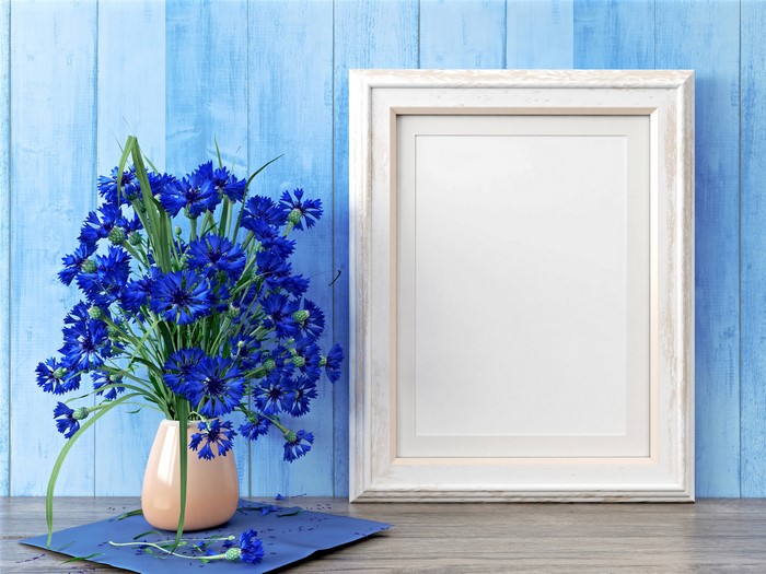 Cornflowers in a vase with a picture frame