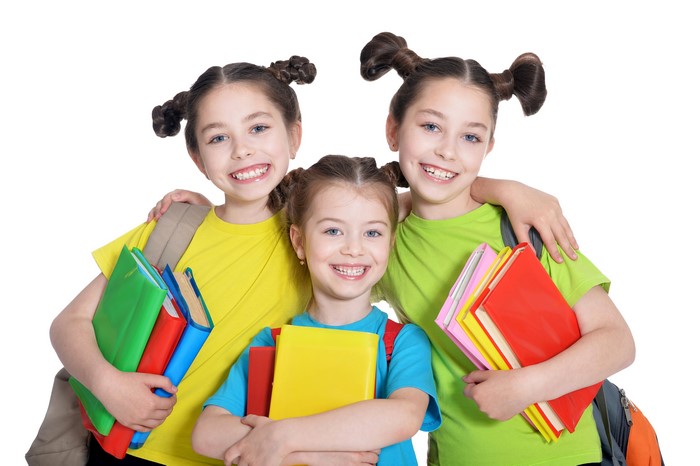 Three little girls with books on white background