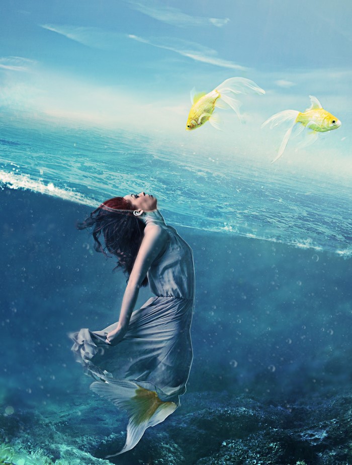 Mermaid in underwater world with two goldfish