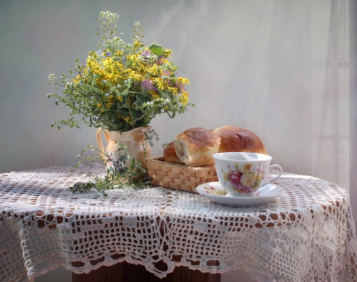 Still-life with wildflowers, buns, and tea cup