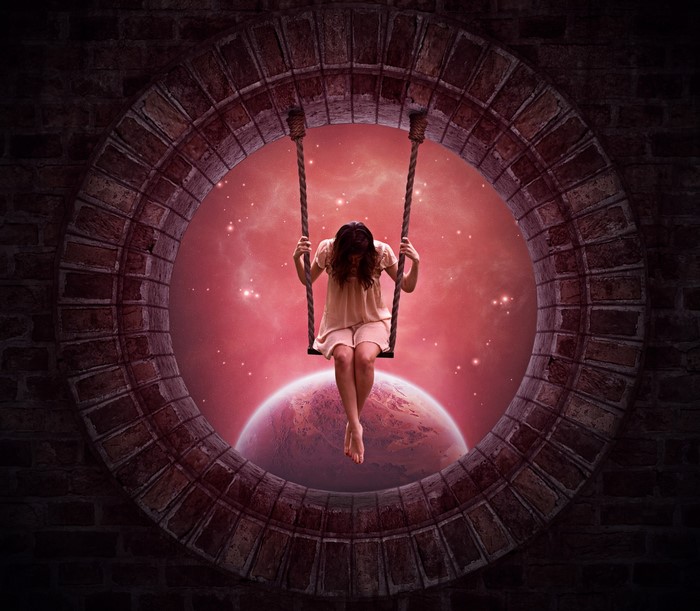 Girl on swing looking at planets through window