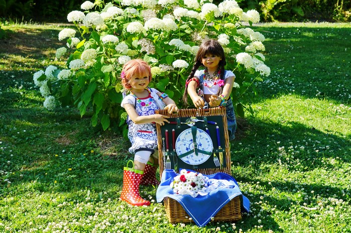Two dolls having a picnic in a park