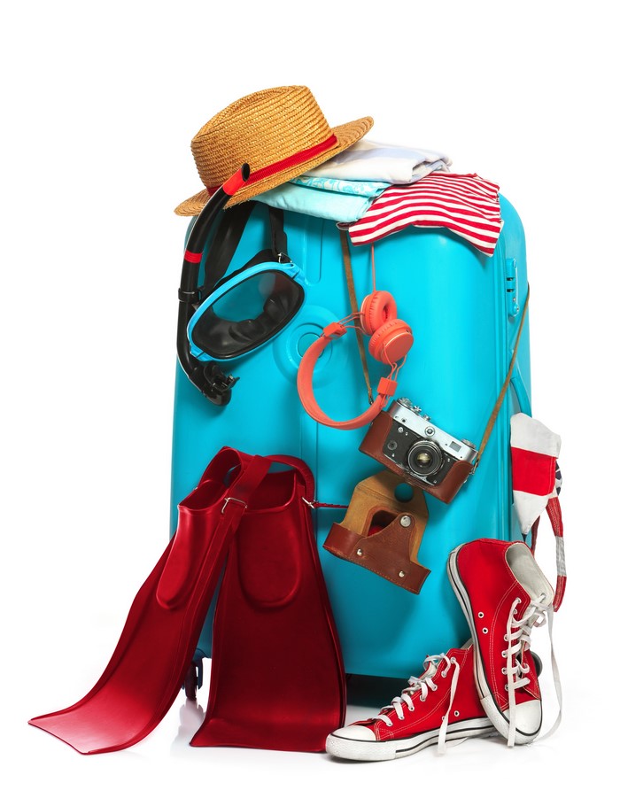Suitcase packed for vacation with hat, snorkel, camera, and shoes