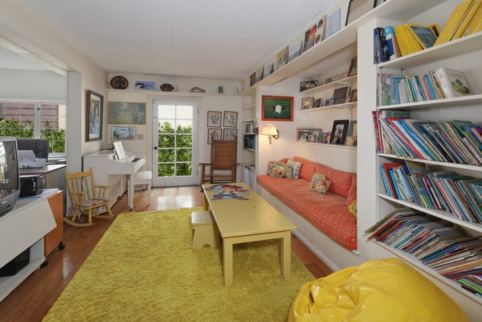 Living room with piano, sofa, and bookshelves