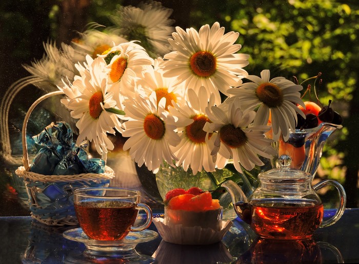 Still-life with tea, camomiles, and fruit