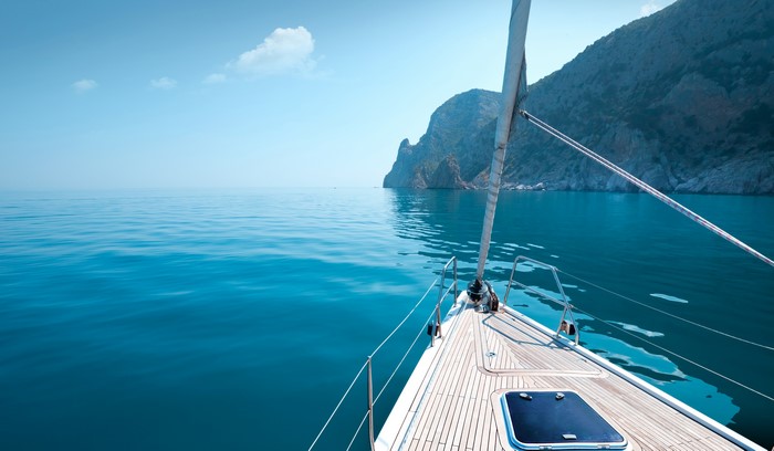 4K Yacht sailing near rocky coast in Greece