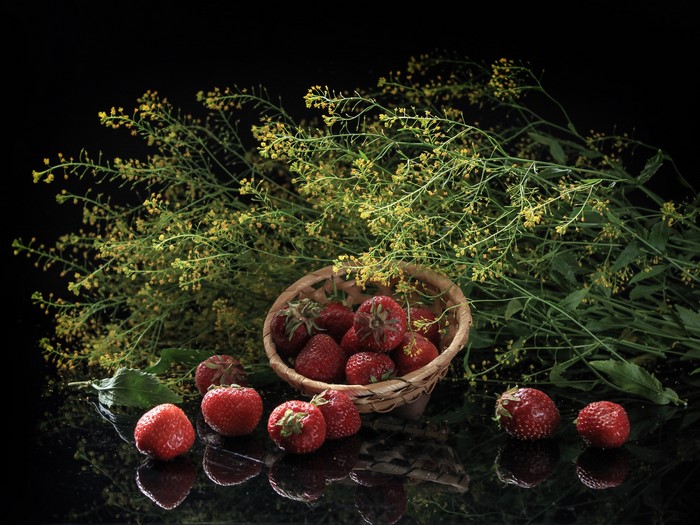 Strawberries in a basket with yellow flowers
