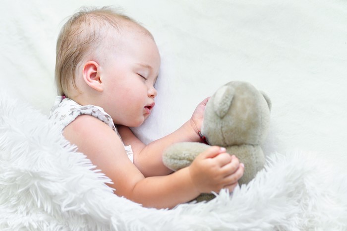 Infant sleeping with teddy bear