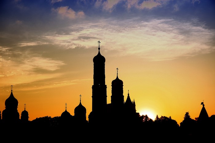 Silhouette of churches against a sunset sky