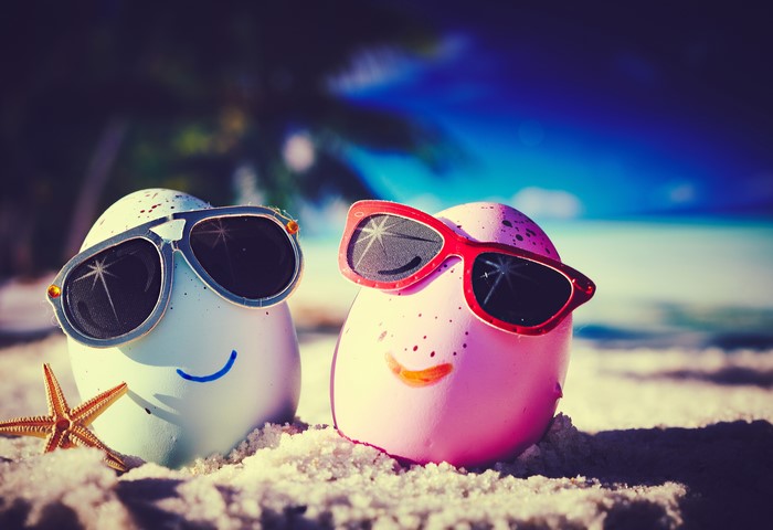 Two eggs with sunglasses on a beach