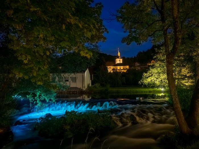 River and buildings at night in Muggendorf, Germany