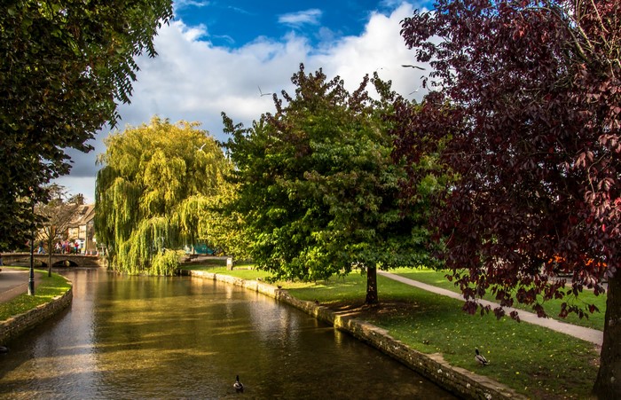 Bourton on the Water canal with trees and bridge