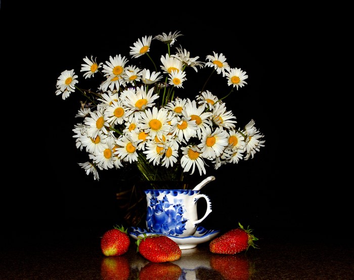 Bouquet of daisies in a cup with strawberries