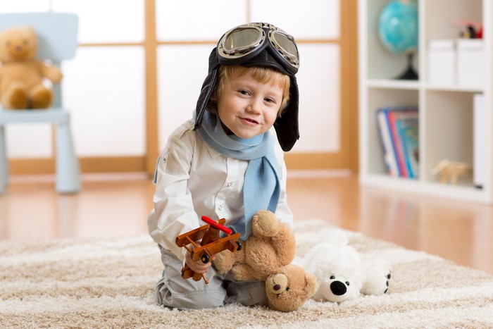 Boy in pilot hat with toys