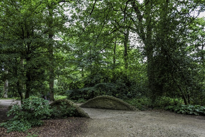 Stone bridge in a green park with trees