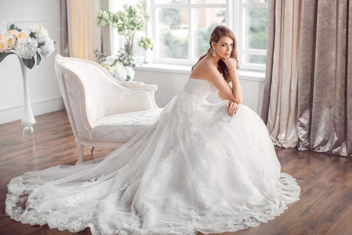 Bride in a white dress sitting on a couch
