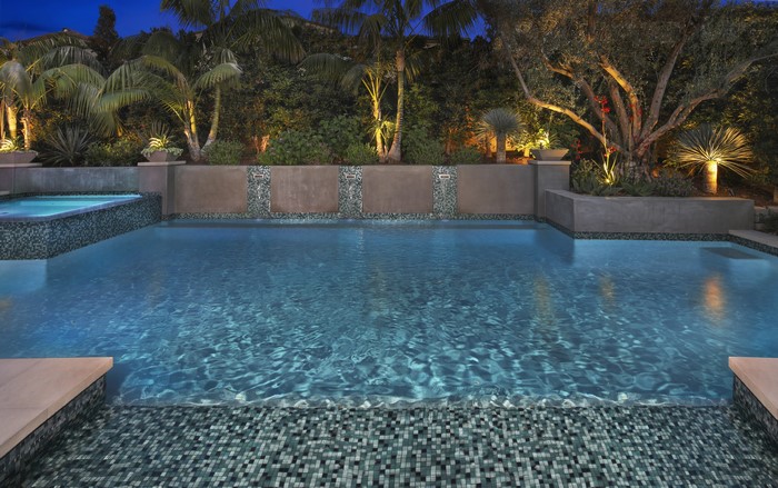 Evening view of a luxury swimming pool and spa
