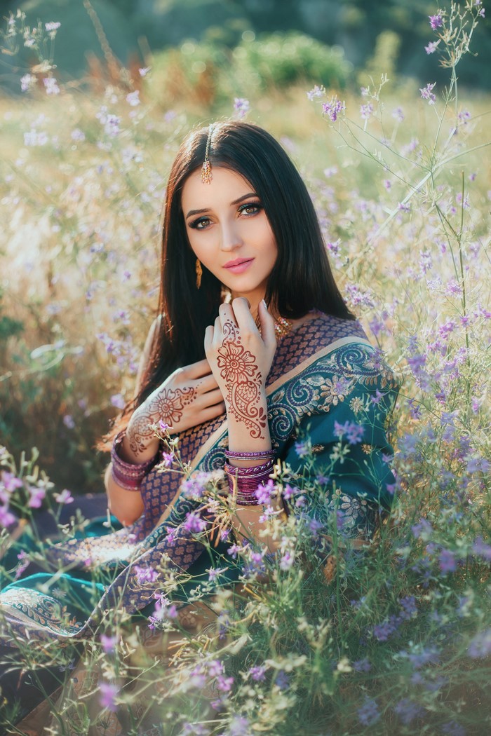Woman with henna tattoos in a field of flowers