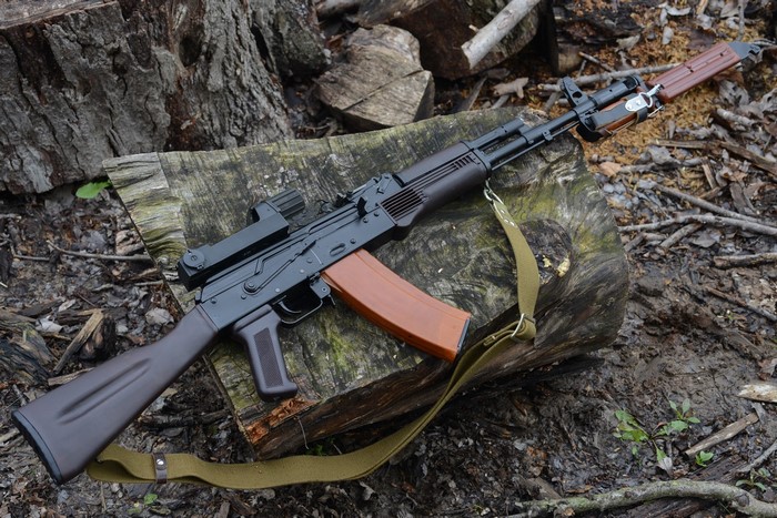 AK-74 assault rifle with optic and sling on logs