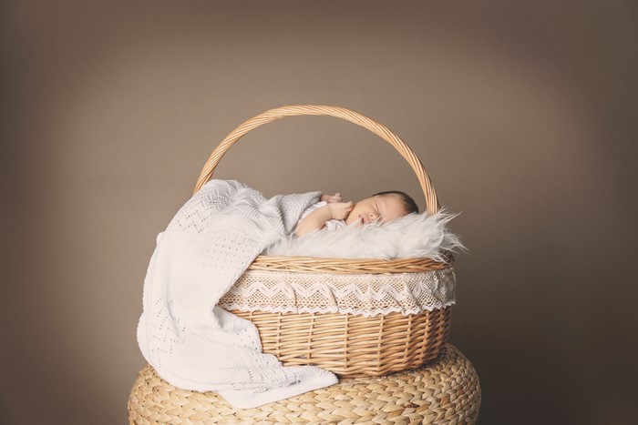 Infant sleeping in a wicker basket