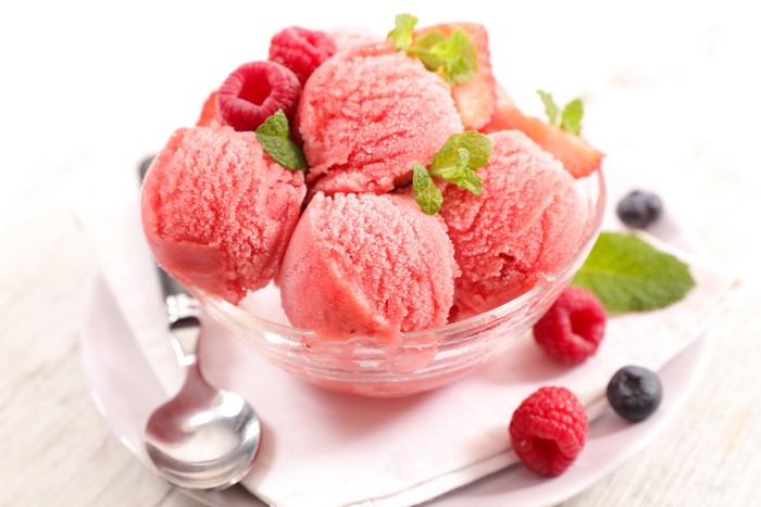 Raspberry ice cream scoops with berries and mint