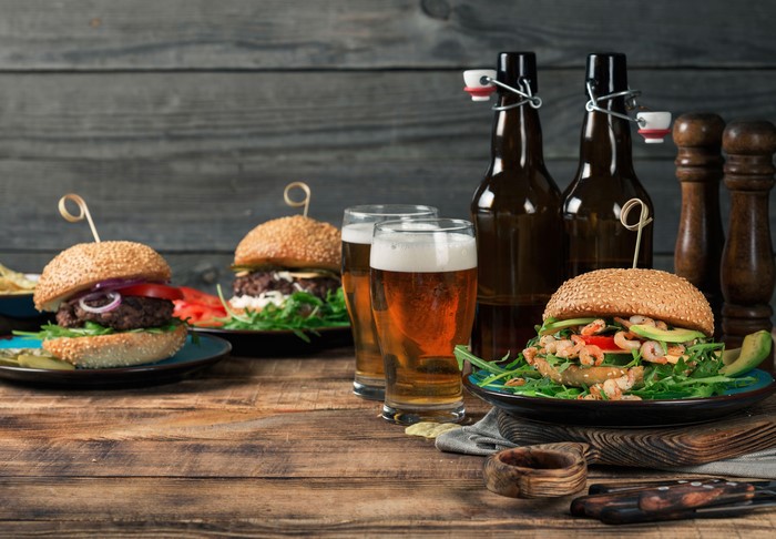 Still-life of hamburgers and beer on wooden planks