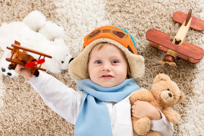 Boy with toys and airplane hat