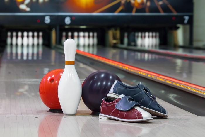 Bowling pins, balls, and shoes on lane