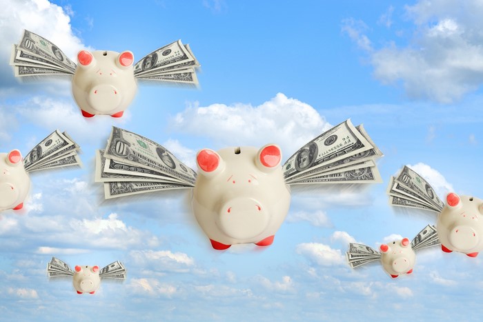 Piggy Banks with Money Wings Flying in Sky