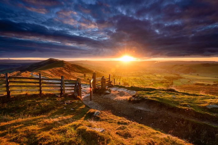 4K Sunrise over rolling hills with wooden fence