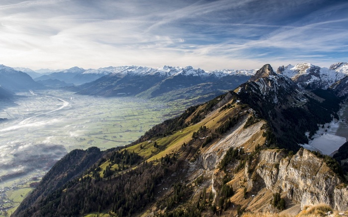 Panoramic view of a mountain valley with snow-capped peaks